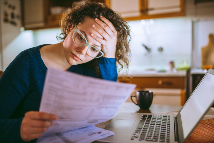 woman looking concerned with bill in hand