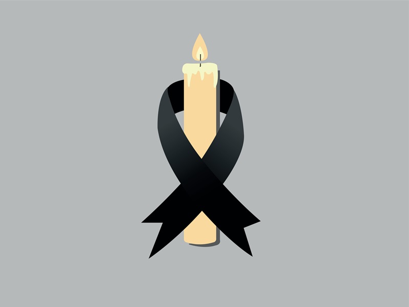 A black ribbon wrapped around a white candle